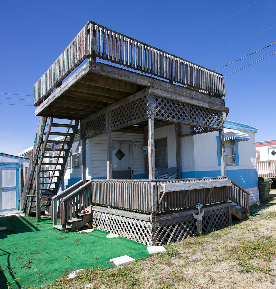 Some travel trailers don't travel at all, they become built into their sites. This raised deck gives a view over the dunes to the Atlantic Ocean. Emerald Beach, North Carolina