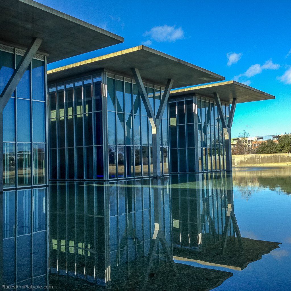 Glass walls and a riverstone filled reflecting pool behind the galleries.
