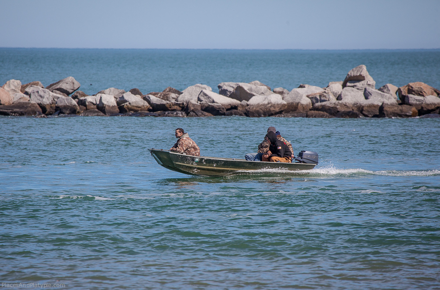 Yep, three men in a tiny boat, returning from the ocean without life jackets.